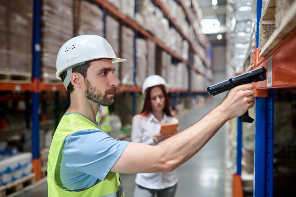 man scanning barcode from cargo woman with tablet